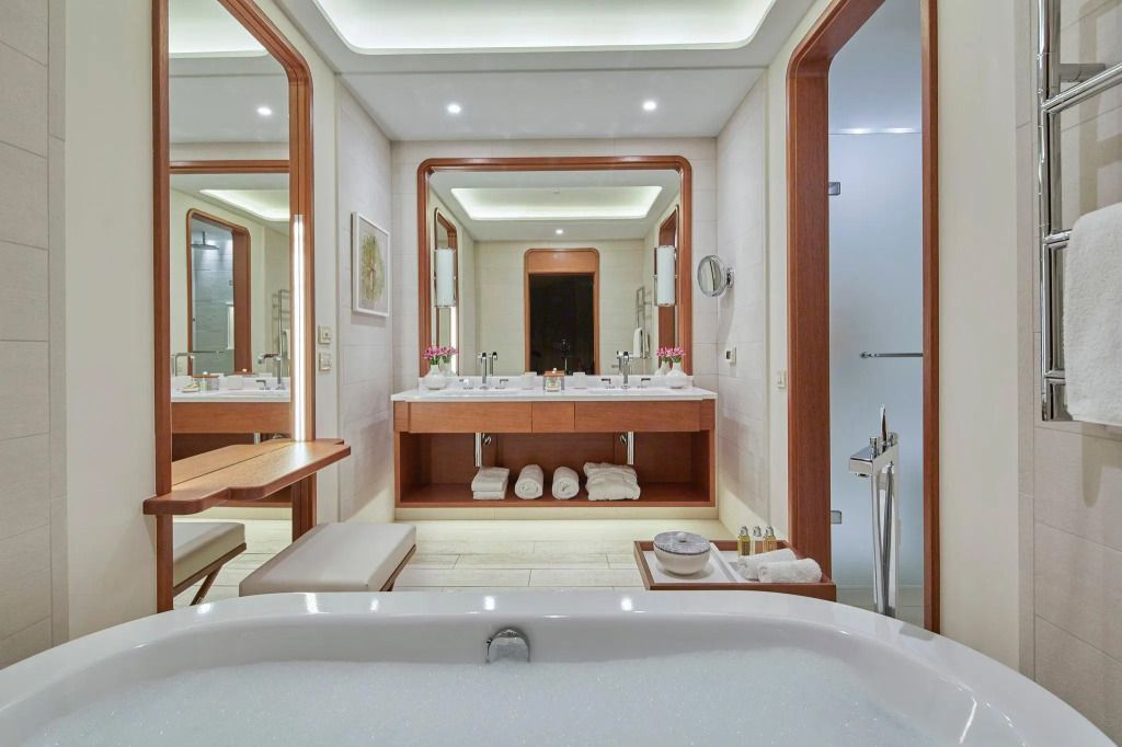 Elegantes Badezimmer mit Doppelwaschbecken und großen Spiegeln im Deluxe Zimmer