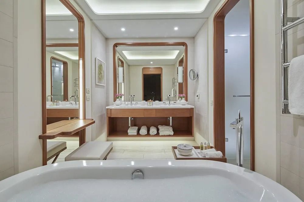 Modernes Badezimmer mit zwei Waschbecken, großer Badewanne und eleganter Beleuchtung.