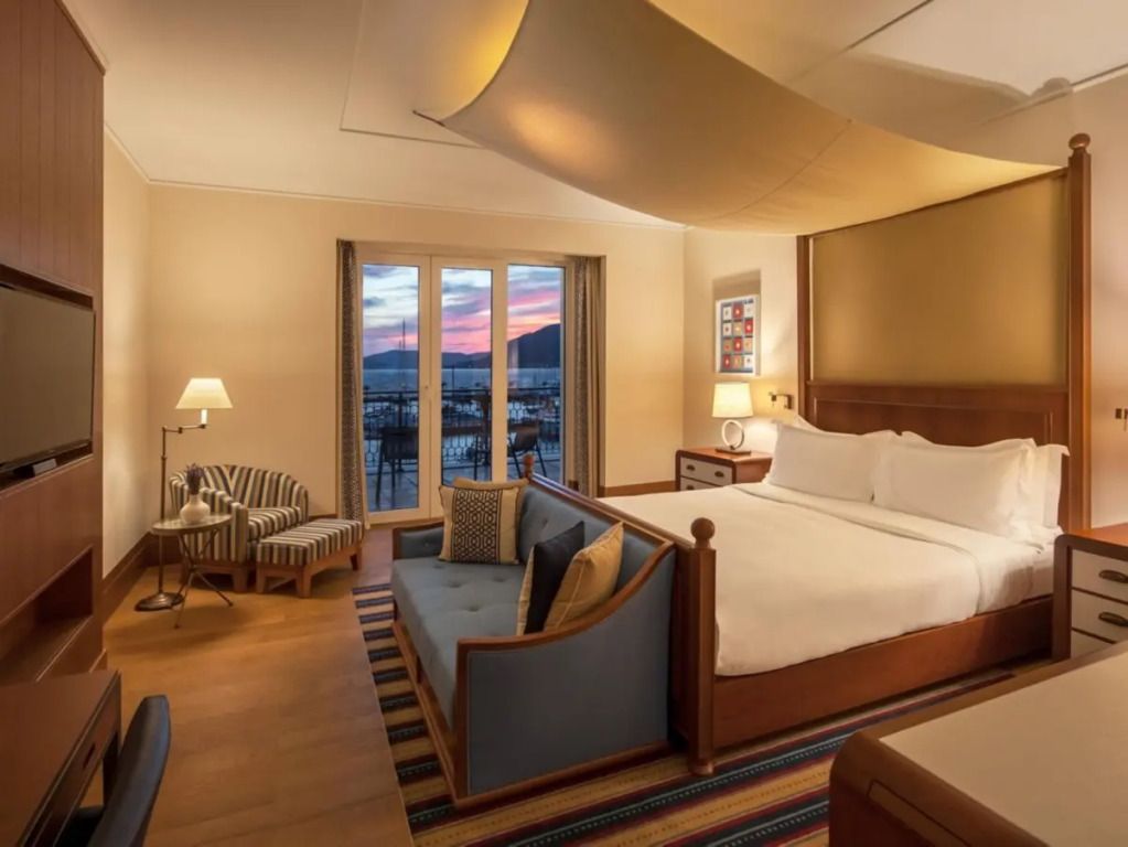Hübsch eingerichtetes Schlafzimmer mit Sofa und Meerblick bei Sonnenuntergang