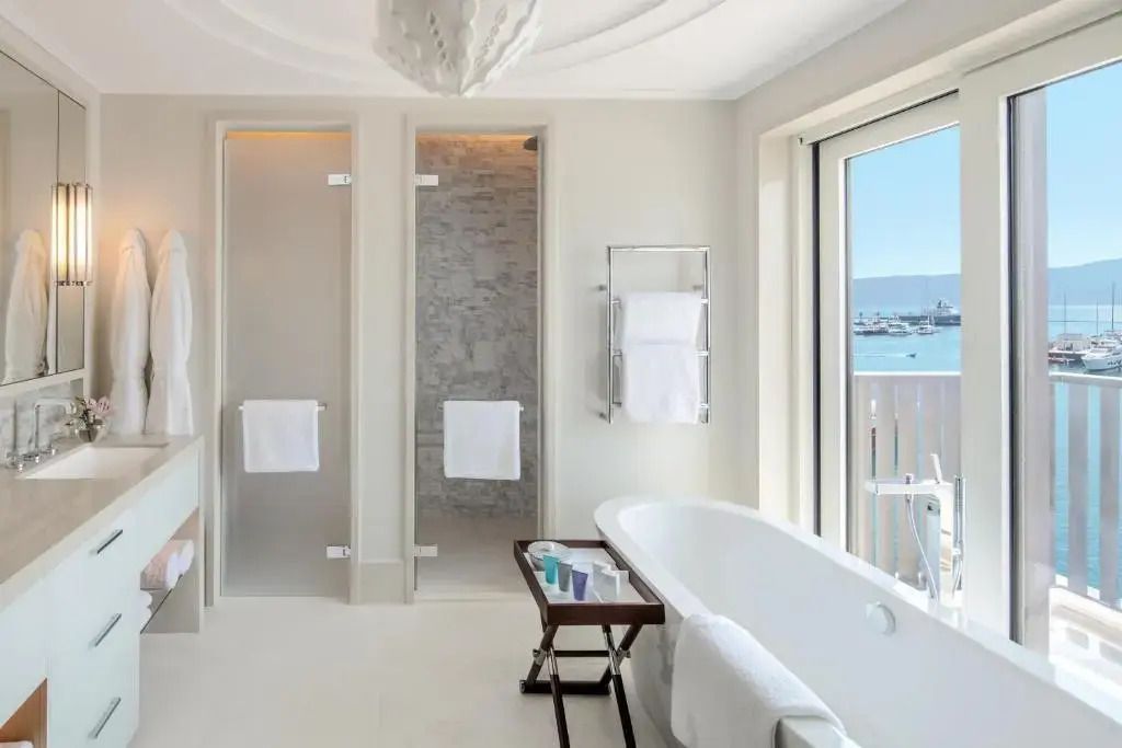 Geräumiges Badezimmer mit Wanne und Meerblick durch ein großes Fenster