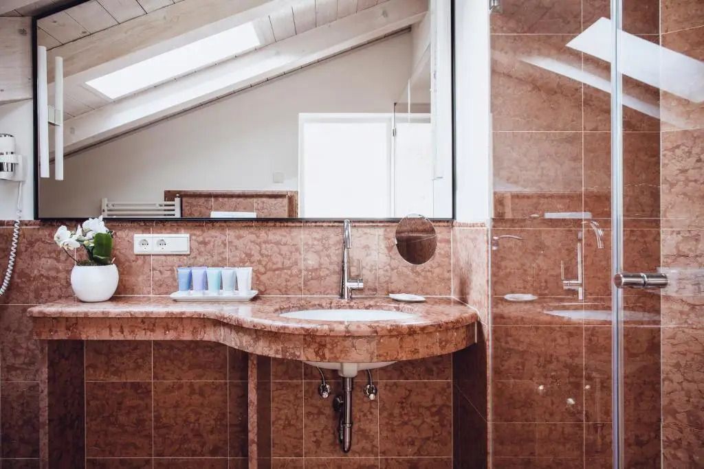 Modernes Badezimmer mit Dachfenster und braunen Fliesen