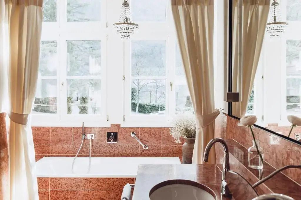 Badezimmer mit Badewanne und großen Fenstern mit Ausblick