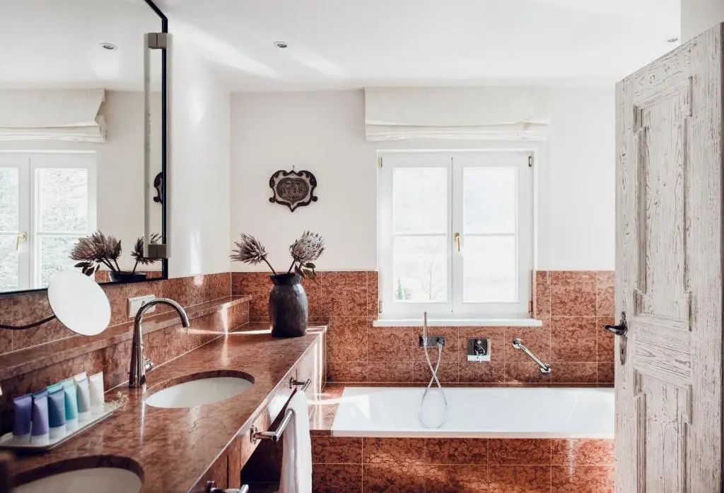 Luxuriöses Badezimmer mit Marmorverkleidung und Fensterlicht