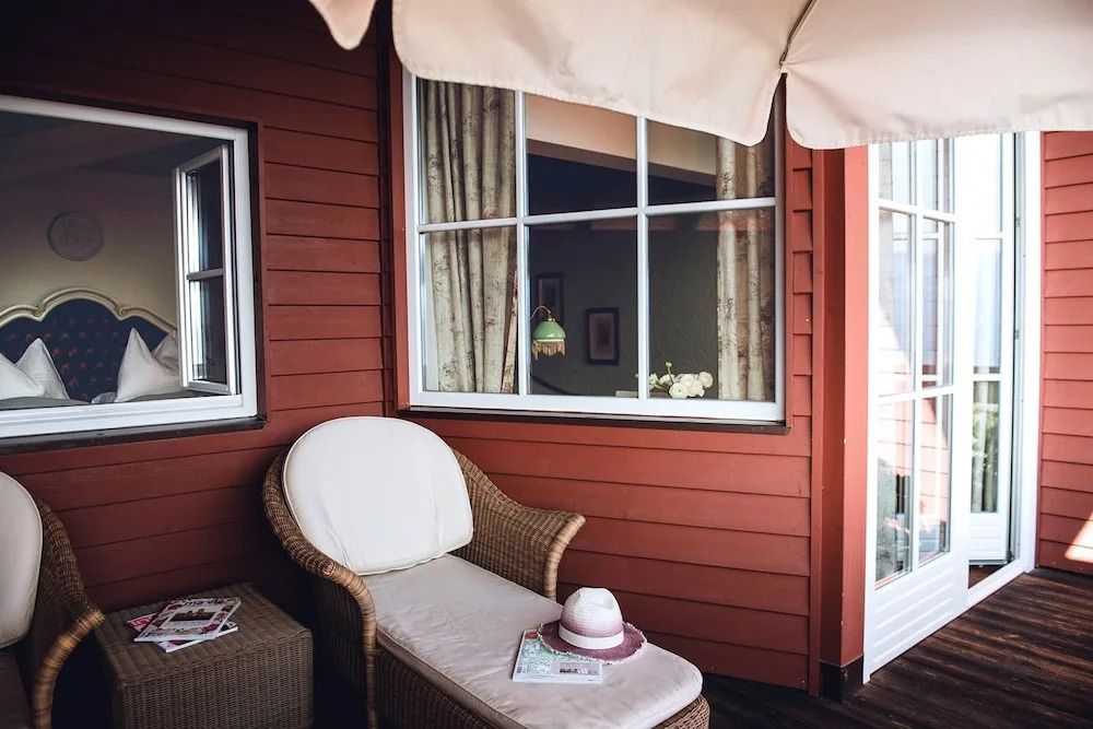 Gemütlicher Balkon mit Liegesessel und Blick ins Zimmer