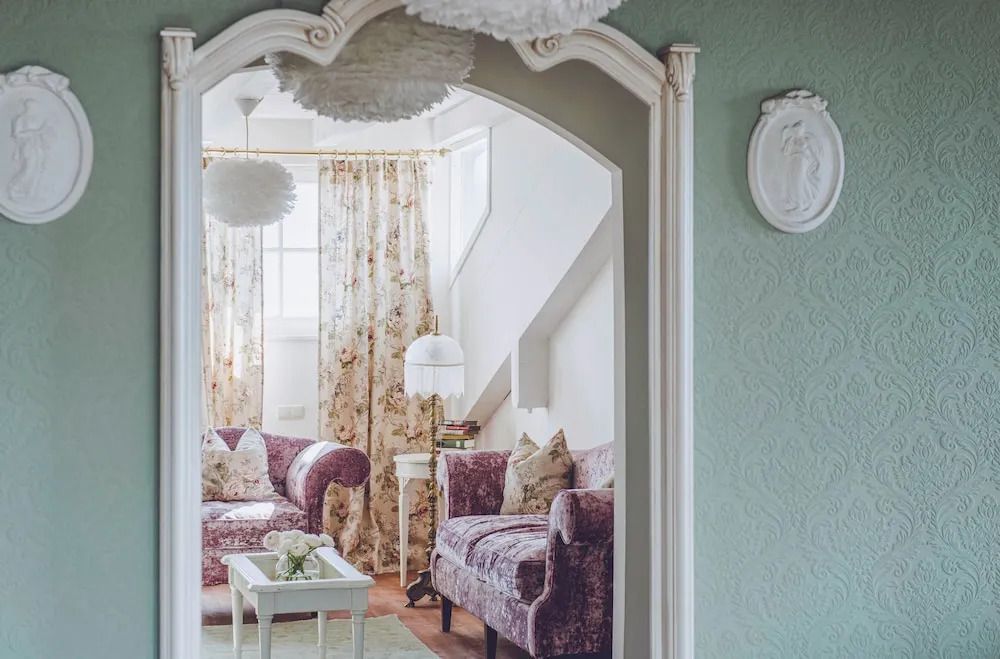 Gemütliches Wohnzimmer mit floralem Sofa und dezenter Beleuchtung