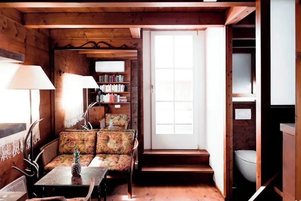 Gemütliche Sitzecke in einer Suite mit elegantem Holzdekor und Bibliothek