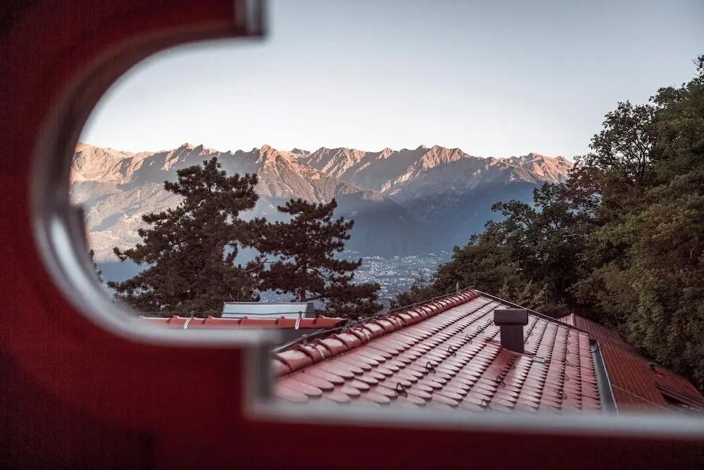 Atemberaubender Blick auf Bergpanorama und Tal durch ein Fenster gerahmt