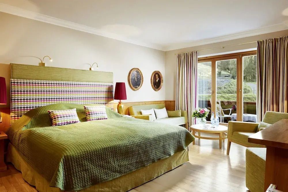 Moderner Doppelzimmerbereich mit Zugang zum Balkon und grünen Akzenten