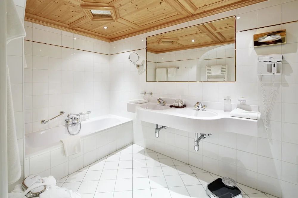 Modernes Badezimmer mit Badewanne, großem Spiegel und Holzakzenten.