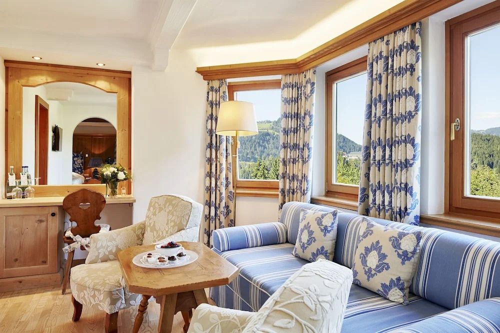 Helle Sitzecke mit Panoramafenstern und traditionellem Dekor in der Suite.