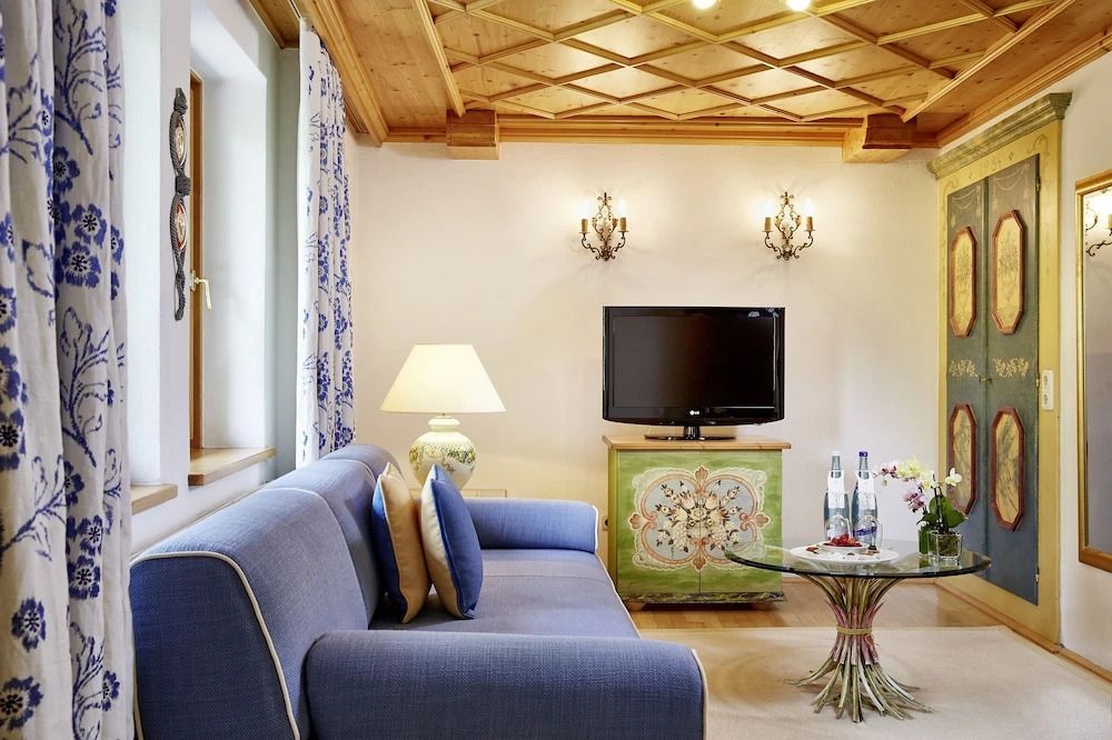Wohnbereich mit blauer Couch und dekorativem Tisch in der Junior-Suite.