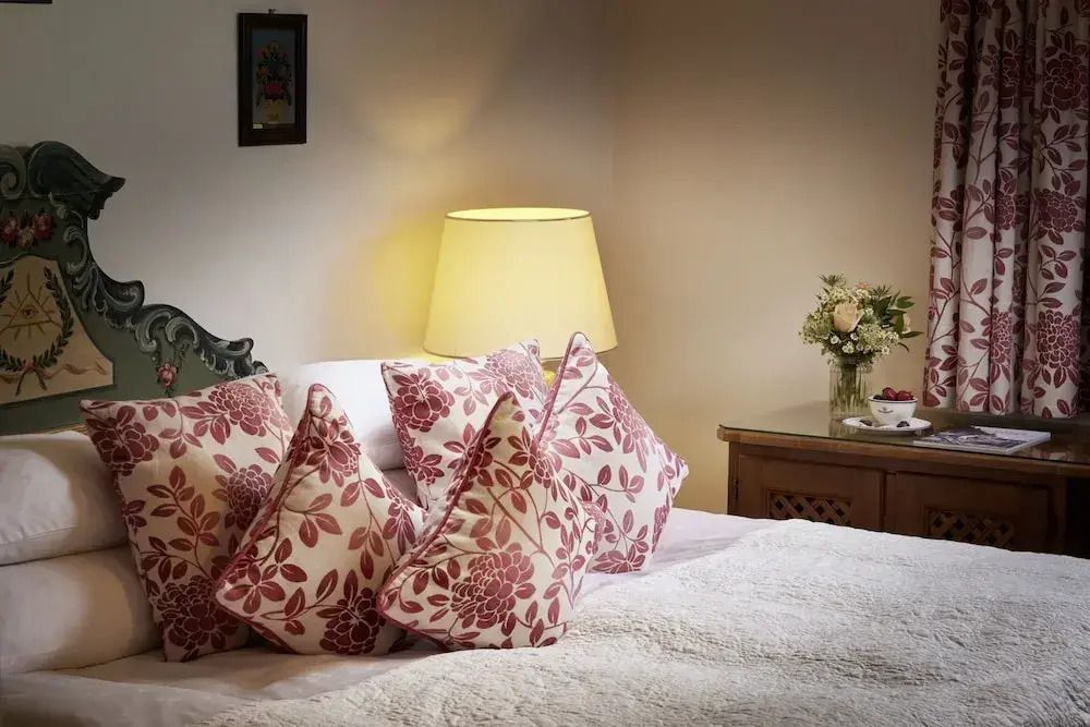 Gemütliches Bett mit floralen Kissen im Standard Doppel Zimmer