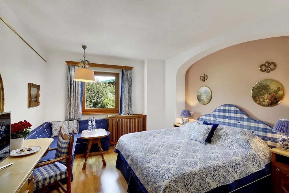 Helles Zimmer mit Doppelbett und Balkonzugang sowie Bergblick