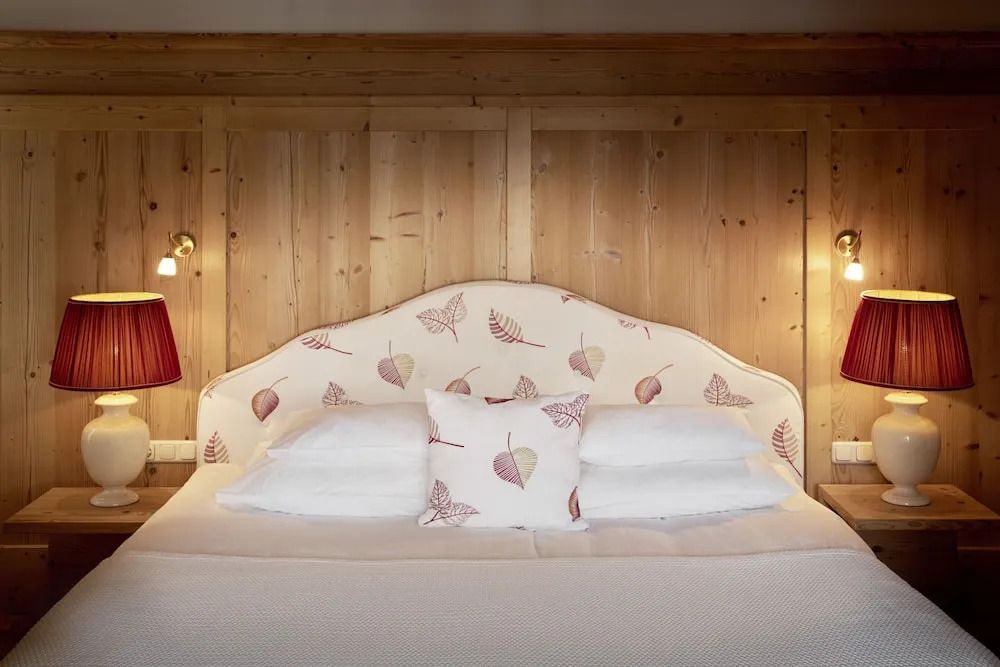 Gemütliches Zimmer mit gepolstertem Kopfteil und Holzvertäfelung an der Wand.