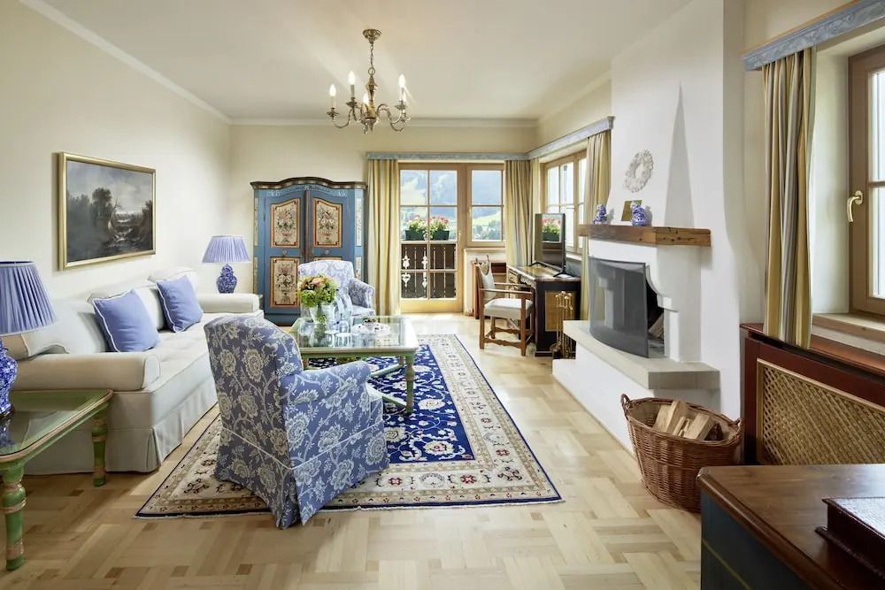 Geräumiges Wohnzimmer mit Kamin, blauen Möbeln und großem Teppich.
