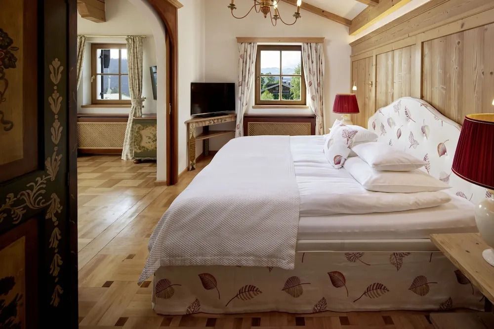 Schlafzimmer mit großem Bett und Blick auf die Berge durch das Fenster.