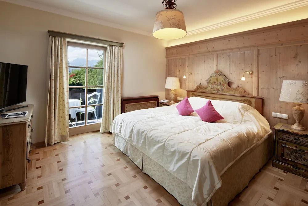 Zimmer mit Doppelbett und direktem Zugang zum Balkon durch Glastüren.