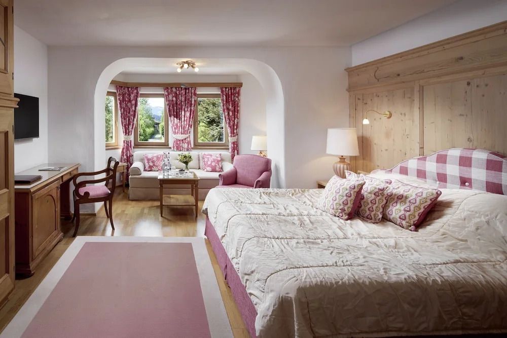 Elegantes Superior Doppelzimmer mit gemütlichem Doppelbett und Balkonblick auf die Berge.