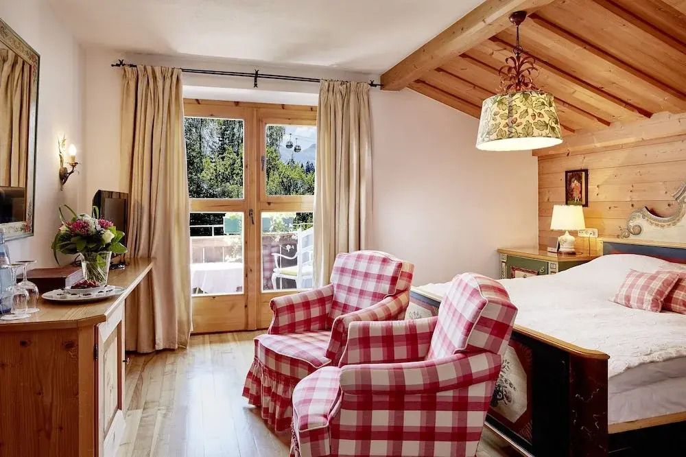 Gemütliches Zimmer mit Holzbalkendecke und Sesseln in rot-weißem Karomuster.