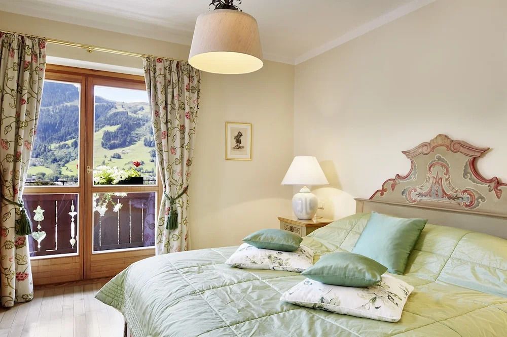 Doppelzimmer mit Pastellfarben und Balkon mit herrlichem Bergpanorama.