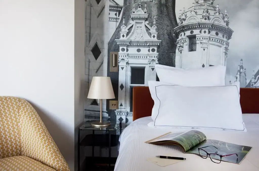 Gemütliches Bett in einem Deluxe Doppelzimmer mit moderner Wandkunst
