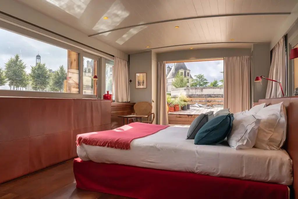 Helles Zimmer mit großem Bett, Blick auf das Schloss Chambord durch große Fenster