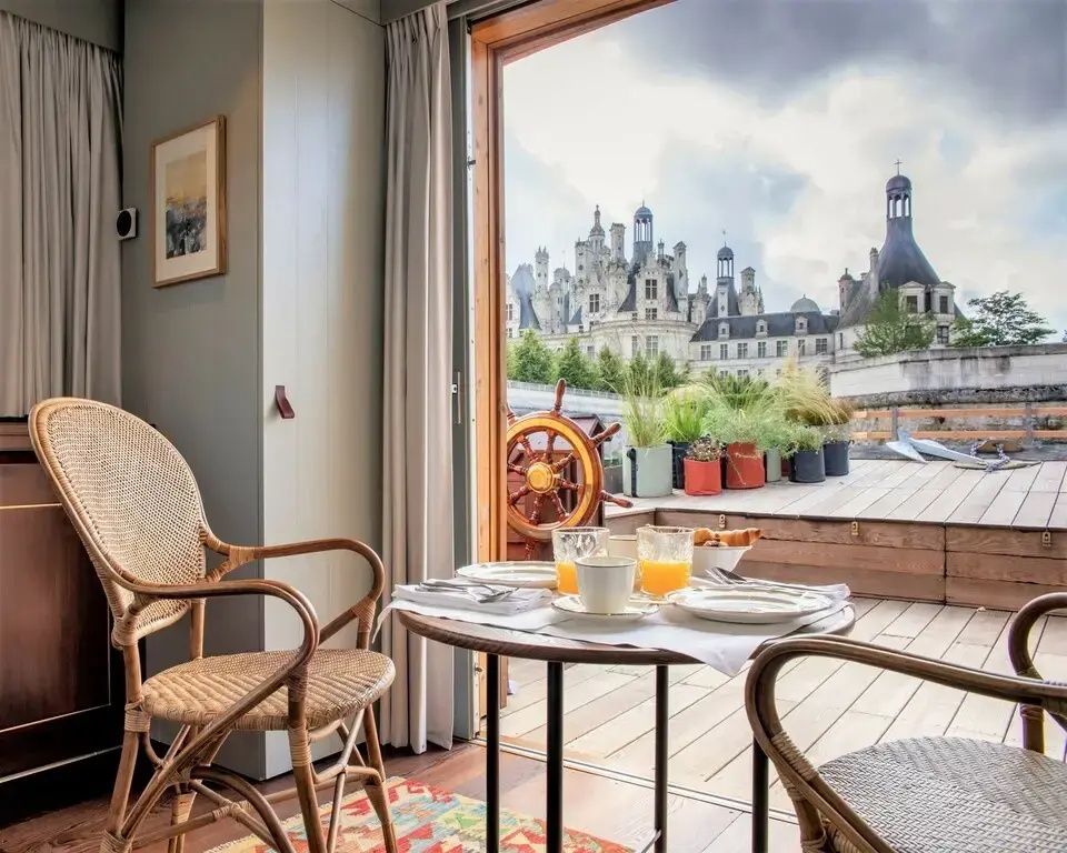 Terrasse mit Frühstückstisch, Blick auf Chambord, Deko in Cremetönen
