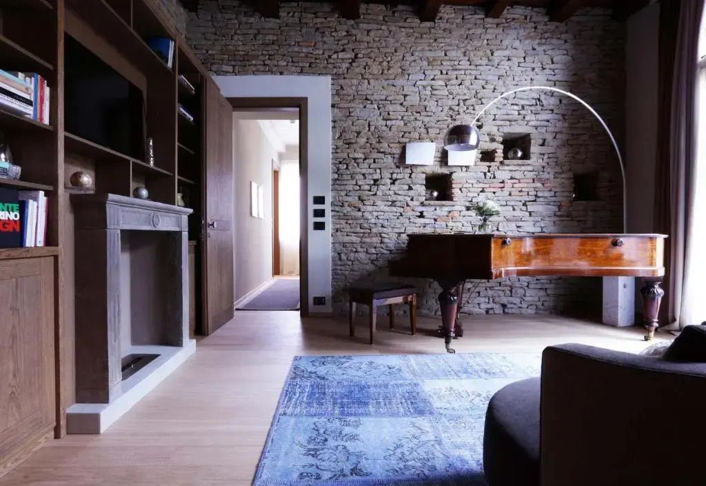 Luxuriöses Wohnzimmer mit Flügel und Steinwand in der Präsidenten Suite