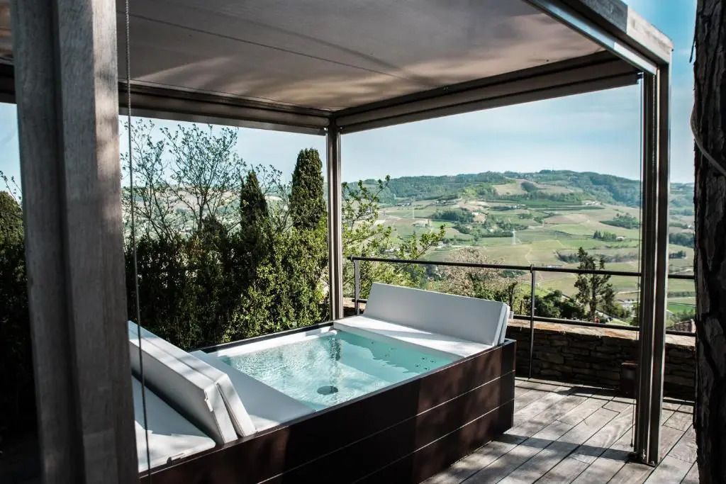 Terrasse mit Whirlpool und Panoramablick auf die umliegenden Hügel