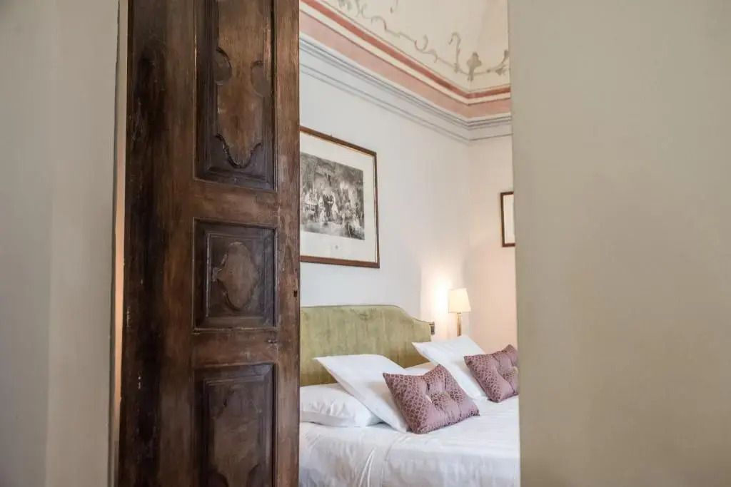 Erlesenes Schlafzimmer mit Holztür und kunstvoller Decke