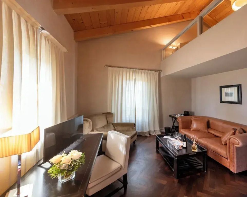 Wohnbereich des Apartments, edle Möbel und hohe Decke mit Holzbalken