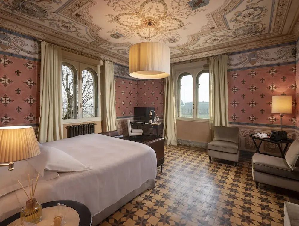 Deluxe Zimmer mit aufwendig dekorierter Decke und großzügigen Fenstern