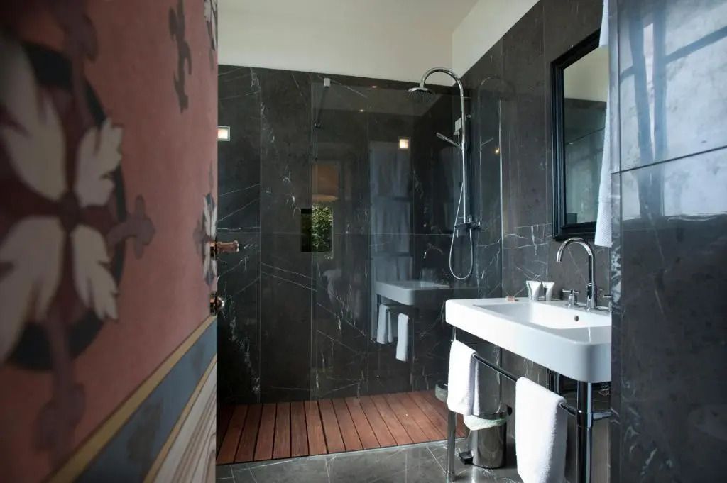 Modernes Badezimmer im Deluxe Zimmer mit Marmordetails und Glasduschwand