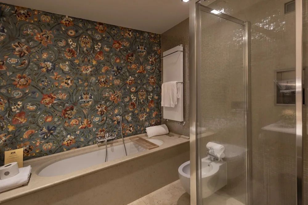 Stilvolles Badezimmer mit dekorativer Fliesenwand und moderner Badewanne.