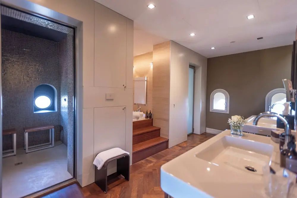 Großzügiges Badezimmer mit Doppelwaschbecken und luxuriösem Duschbereich.