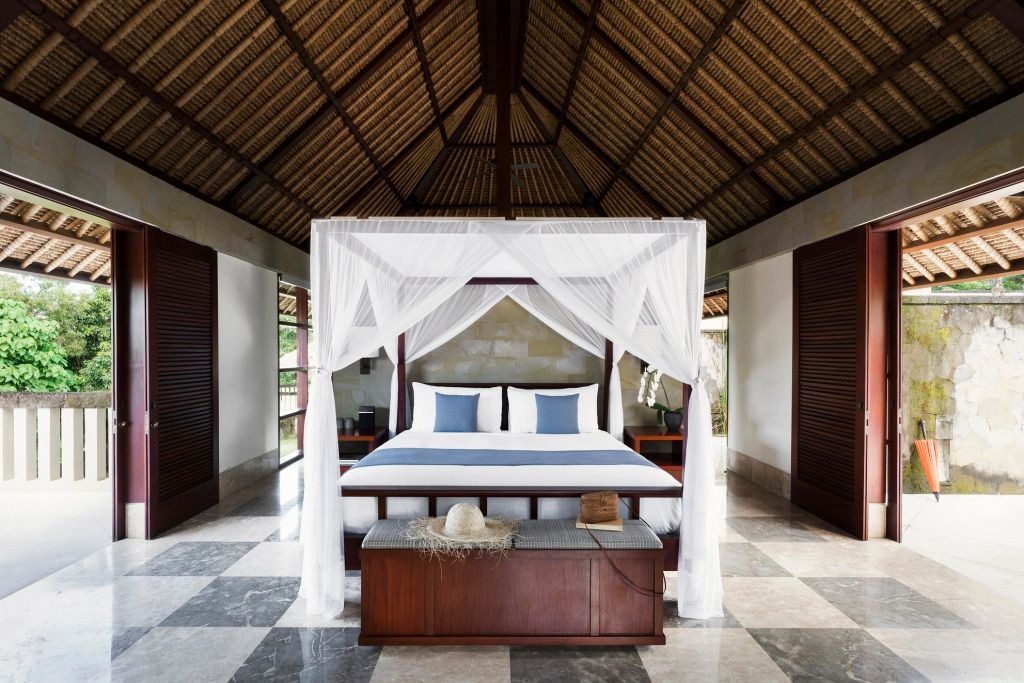 Luxuriöse Suite im tropischen Stil mit Himmelbett und Steinfliesen im REVIVO Wellness Resort.