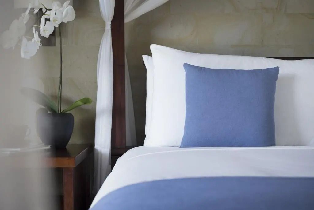 Detailansicht eines Bettes in der Suite mit blauer Bettwäsche und eleganter Dekoration.