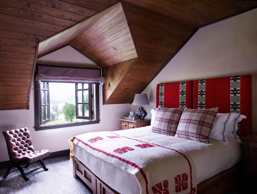 Elegantes Schlafzimmer mit Holzdecken und Fenster mit Gartenblick