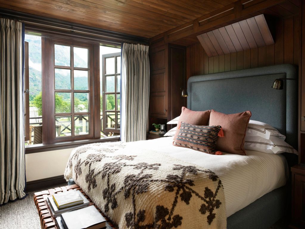 Komfortables Schlafzimmer mit Fensterfront und Blick in die Natur