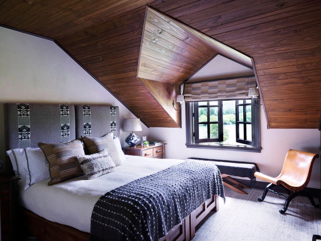 Dachgeschosszimmer mit Holzdecke und hellen Möbeln für ein einladendes Ambiente