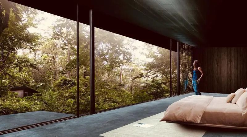 Großes Fenster mit Blick in den Wald in einem modernen Zimmer mit Doppelbett