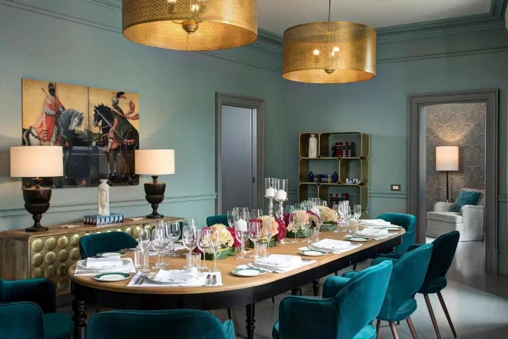Edler Speiseraum mit elegant gedecktem Tisch und goldenen Deckenleuchten