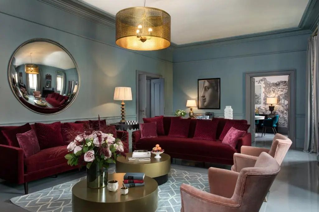 Luxuriöses Wohnzimmer mit Samtsofas und dekorativem Rundspiegel
