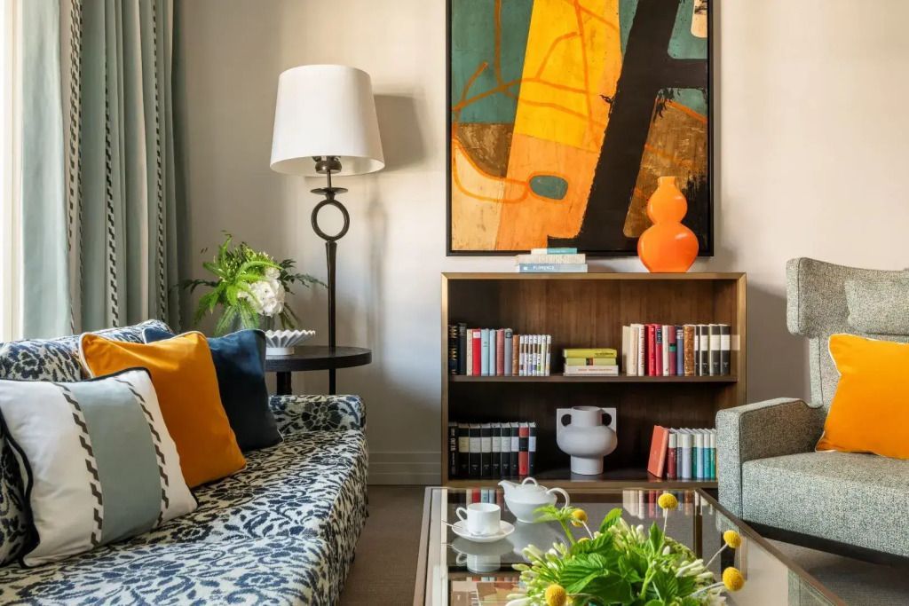 Detailansicht des stilvollen Wohnbereichs mit Kunstwerk und Bücherregal.