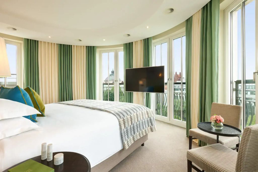 Helles Schlafzimmer mit rundem Fensterbereich und Doppelbett in der Forte Suite.