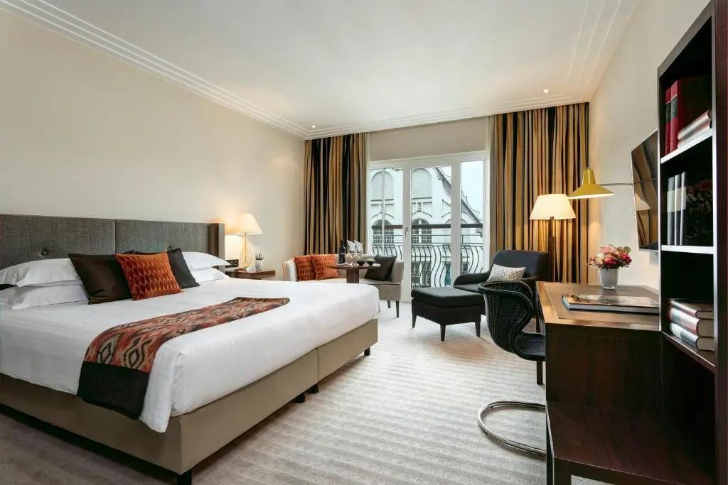 Elegantes Doppelzimmer mit raffiniertem Dekor und großen Fenstern für viel Tageslicht.