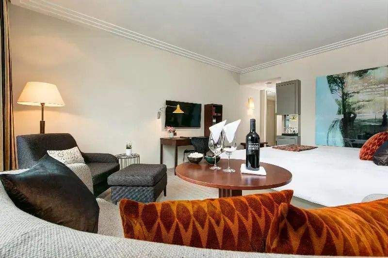 Gemütlicher Sitzbereich im Hotelzimmer mit moderner Ausstattung und Getränkepräsentation.