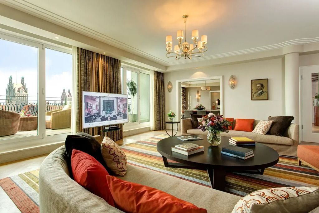 Wohnbereich der Suite mit stilvoller Einrichtung, großem Sofa und Flachbildschirm