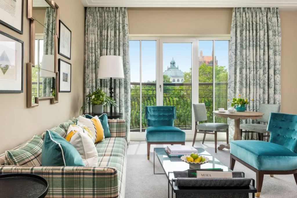 Gemütlicher Wohnbereich mit Sofa, Sesseln und Zugang zum Balkon.