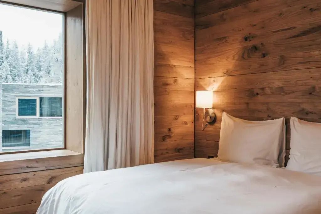 Schlafzimmer aus Holz mit bequemem Bett und Fenster